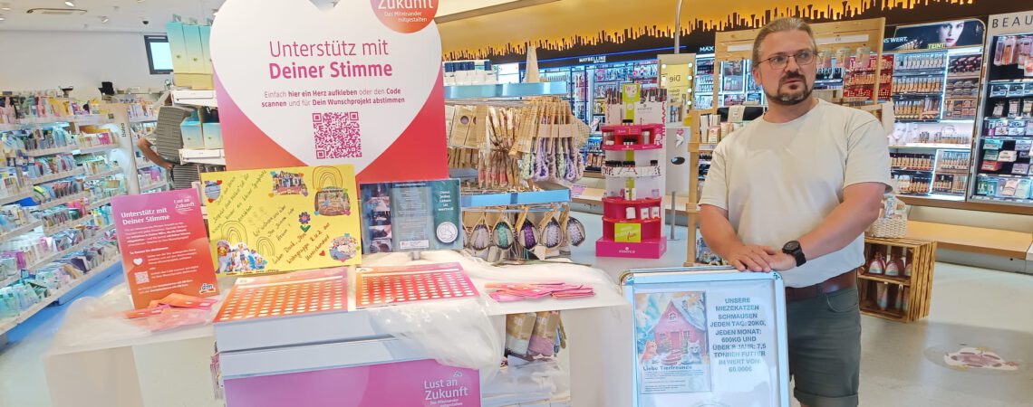 Steffen von der Katzenstation steht am Unterschriftenstand im dm-drogerie markt in Fredersdorf