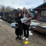 Eine Frau und ein Mann, die eine Katze in der Transportbox haben und sie adoptieren.